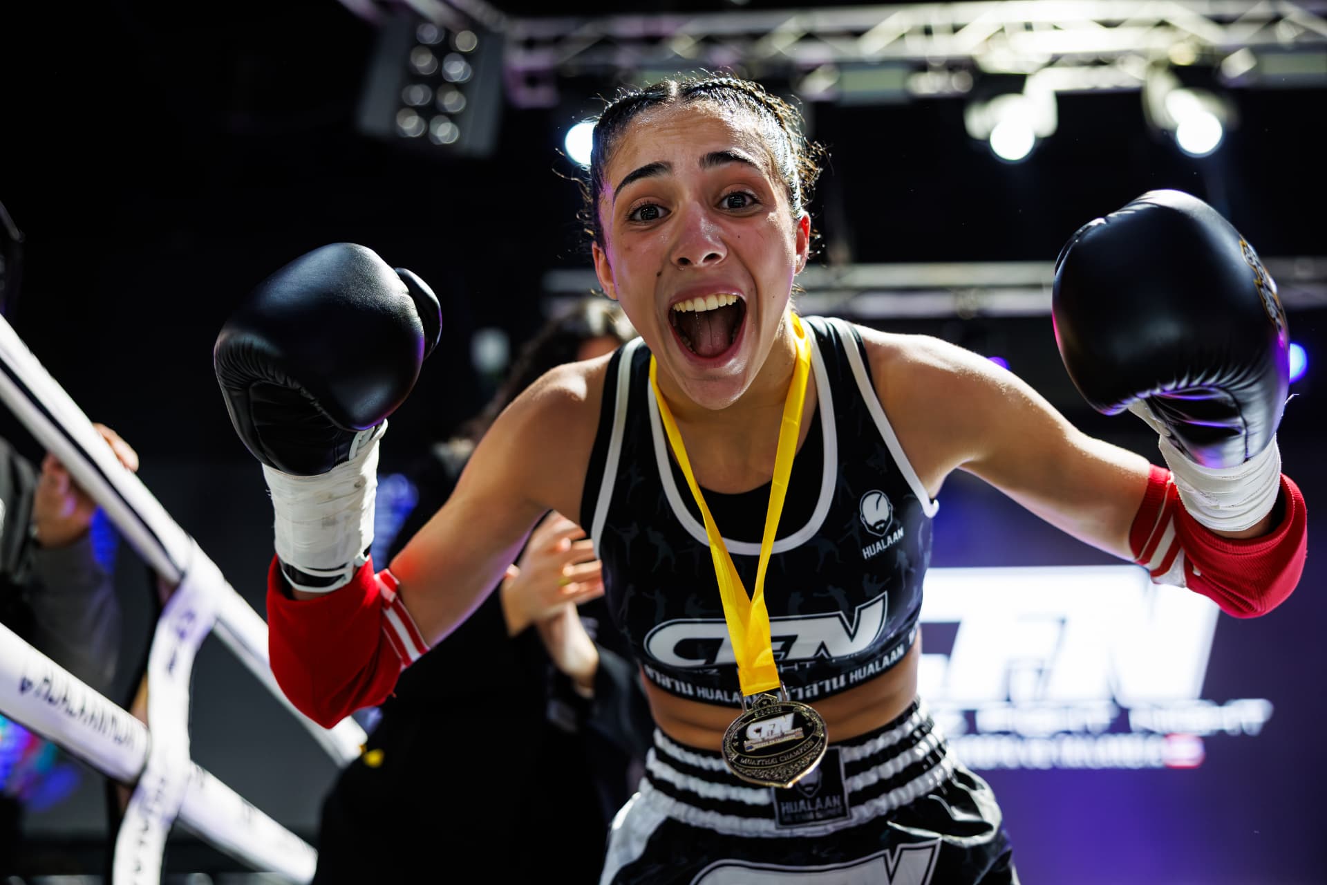 Luchadora de CFN celebrando con la medalla de campeona sobre el ring
